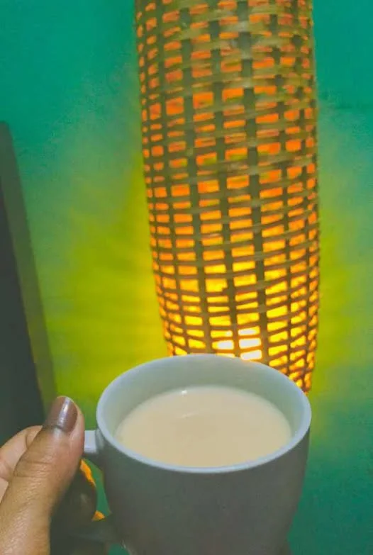 Customer photo: a cup of tea beside a lit bamboo lamp